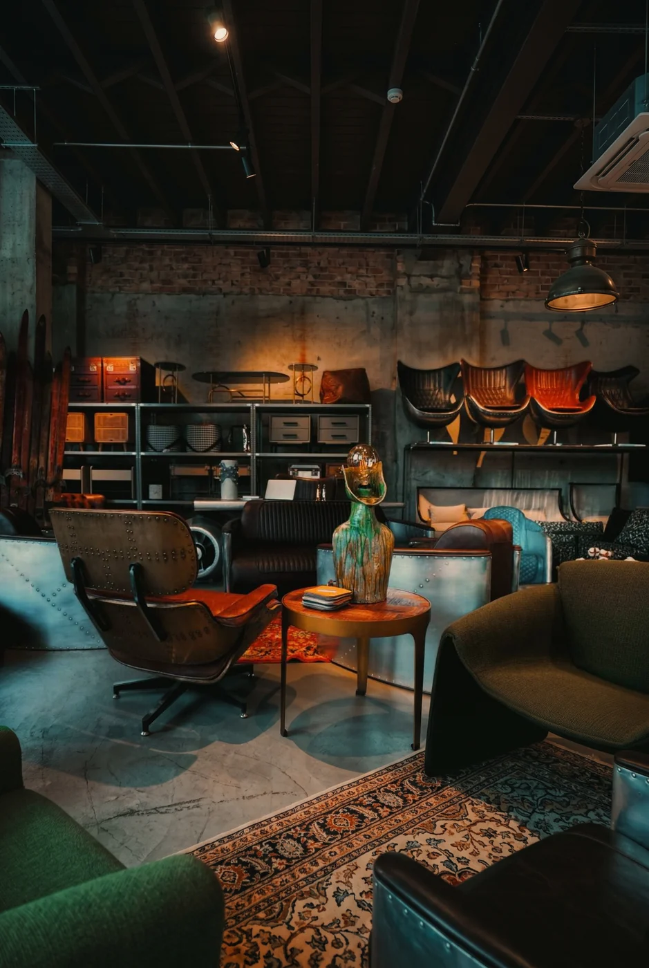 Зал шоу-рума OLD LOFT: кресло-авиатор, клёпаный диван и латунные кресла Aviator на стеллаже — мебель в наличии в лофт-шоуруме